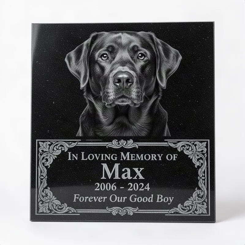Thin polished black granite statement marker tile with large laser-engraved grayscale dog portrait, ornate border, name, dates, and Forever Our Good Boy message